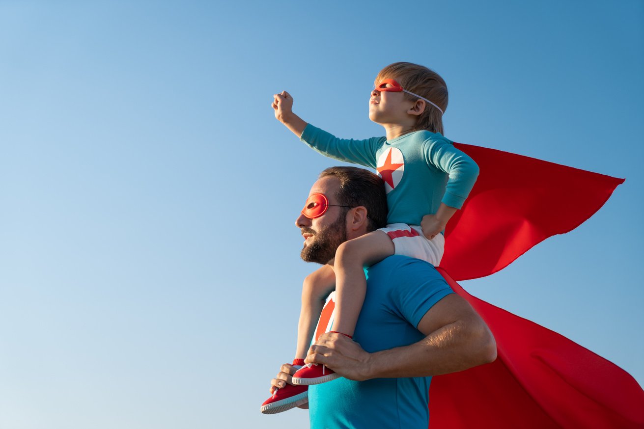 Father and Son Playing Outdoors Wearing Capes and Masks